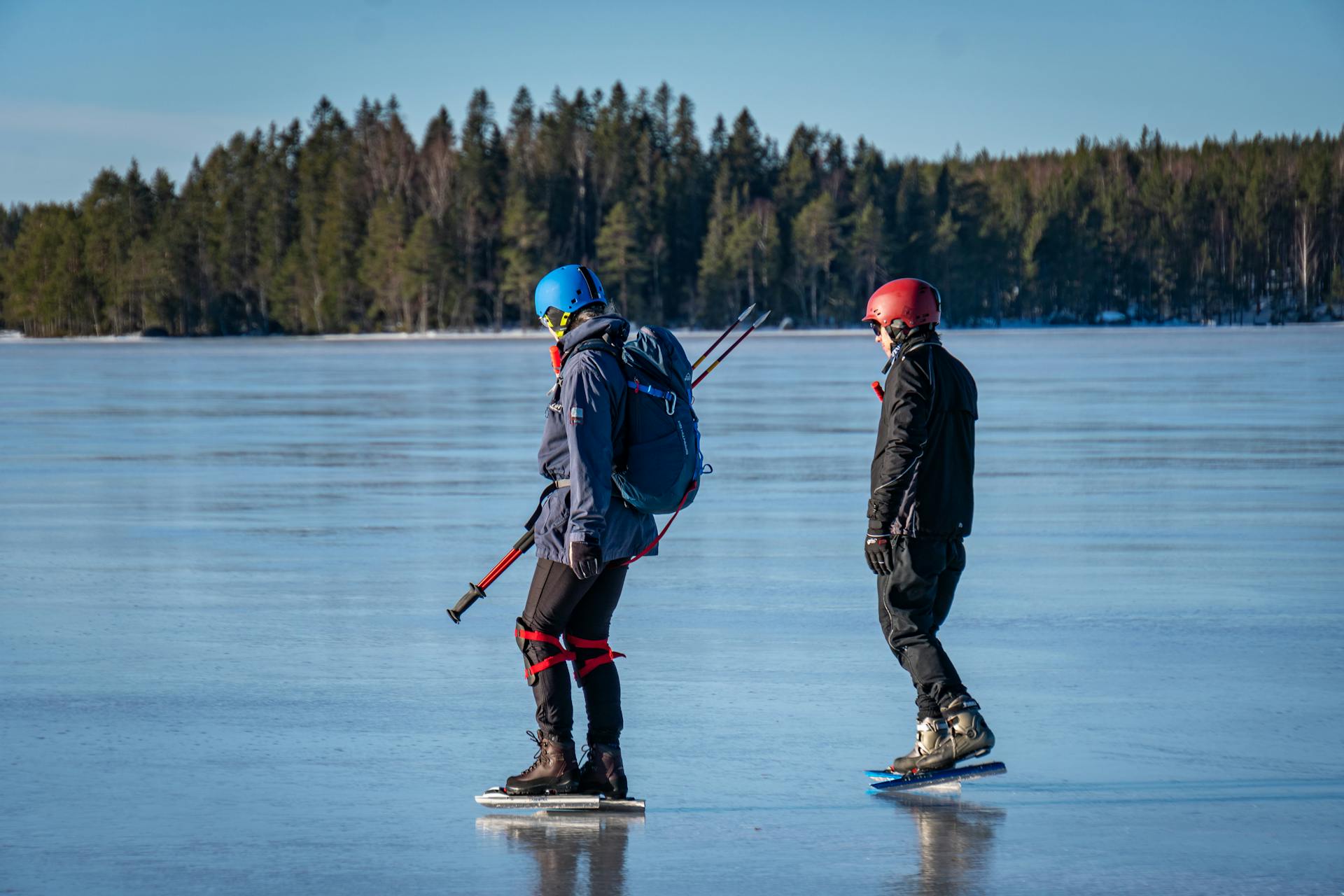 A ice skating duo up close during a guided ice skating tour with blue sky and ice in the background.
