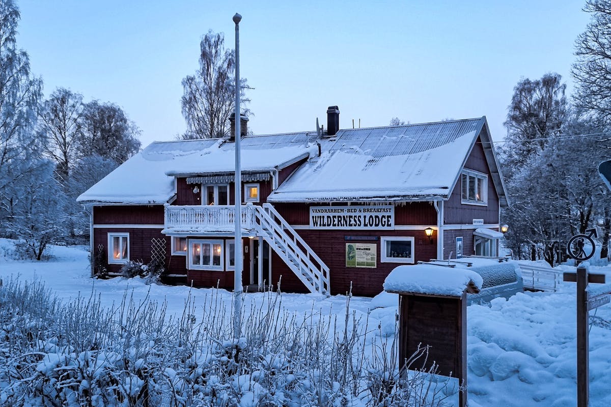 Experience the enchanting beauty of a traditional Swedish Wilderness Lodge in winter. Immerse yourself in a snowy wonderland surrounded by picturesque landscapes and cozy accommodations.