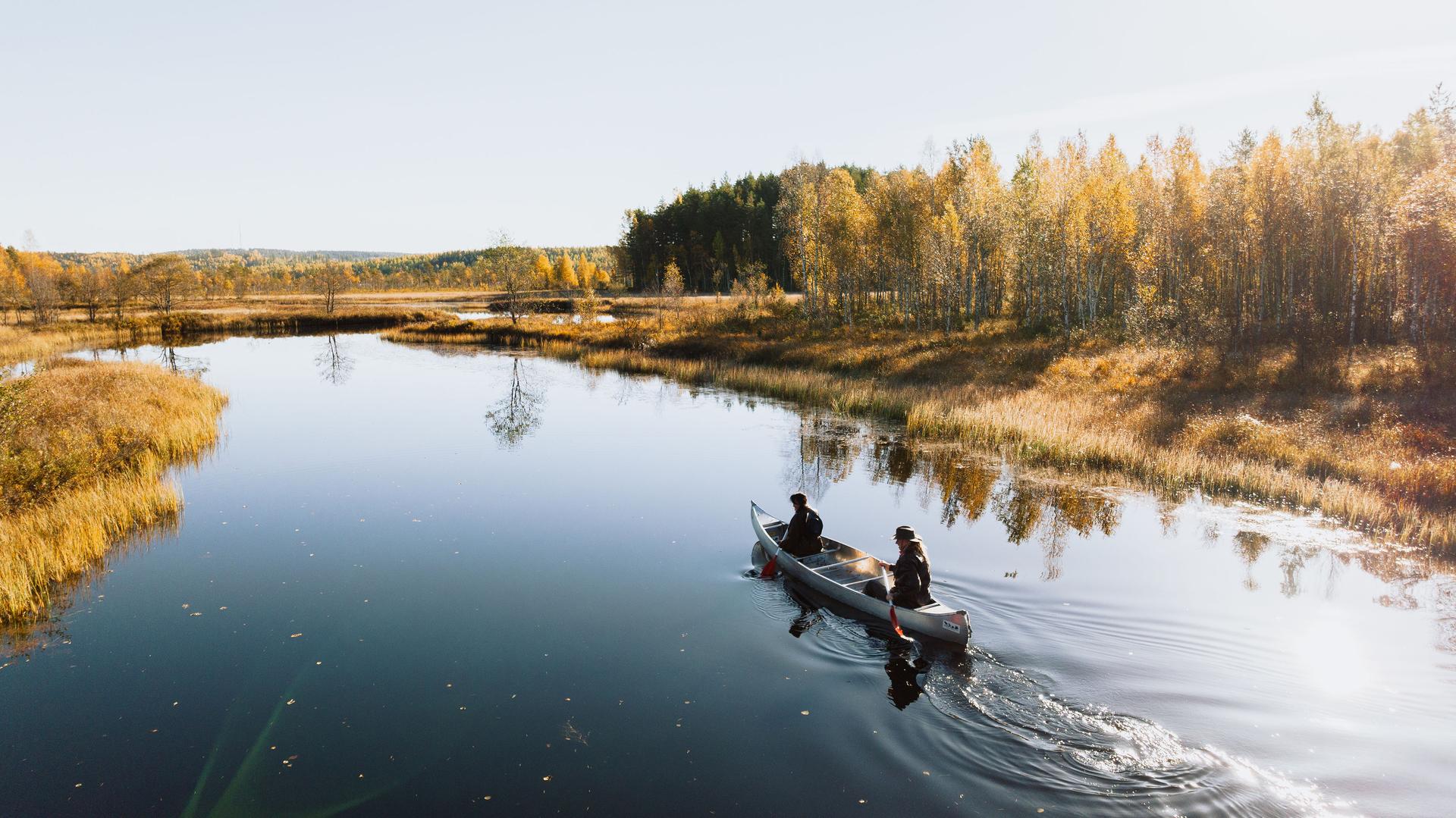 Un couple profite de la nature calme et immaculée en pagayant sur une eau miroir.