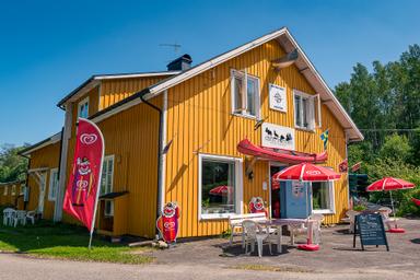 Nordic Discovery's äventyrscenter i Malingsbo-Kloten naturreservat. Byggnaden är gul med en röd kanot över entrén.