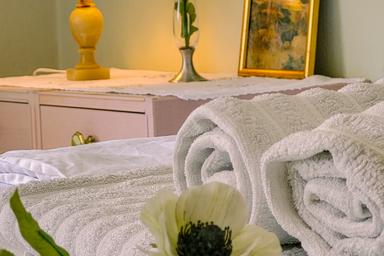 Close-up van handdoeken, bed en bloemen bij de wilderness lodge.