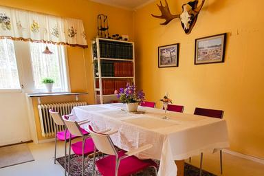 Esstisch mit Stühlen in der Küche in der wilderness lodge. Elchgeweihe an der Wand.