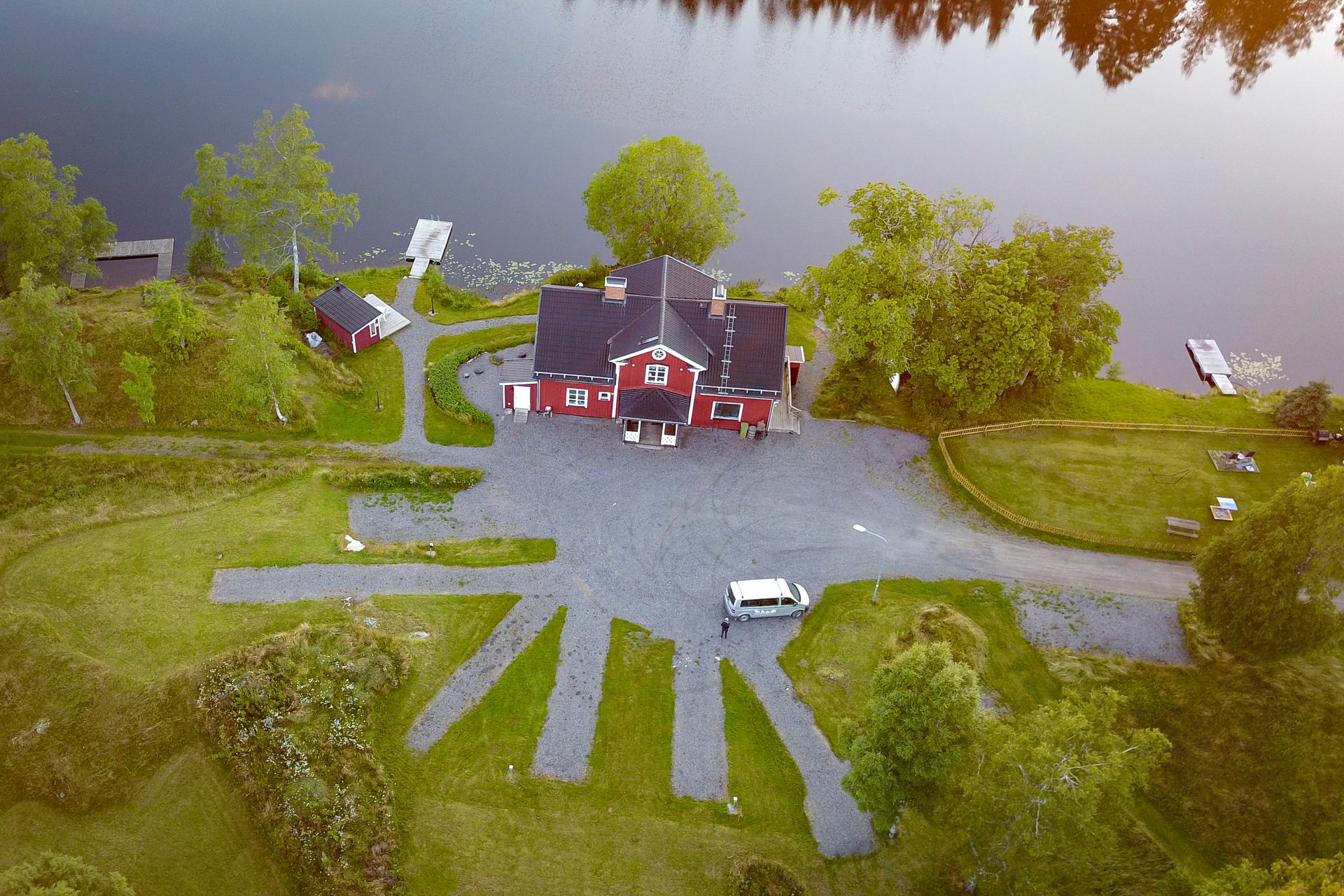 A bird's-eye view of the river lodge with sauna, swimming area, deck, and large veranda.