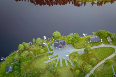 Aerial view of the River Camping. The water is calm and camping area is surrounded by wilderness.