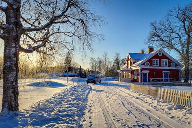 Eine schneebedeckte Straße, die zur Flusslodge mitten im schwedischen Winter führt.