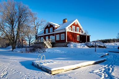 La cubierta en River Lodge está cubierta de nieve en un frío día de invierno. La nevada naturaleza salvaje sueca es visible en el fondo.
