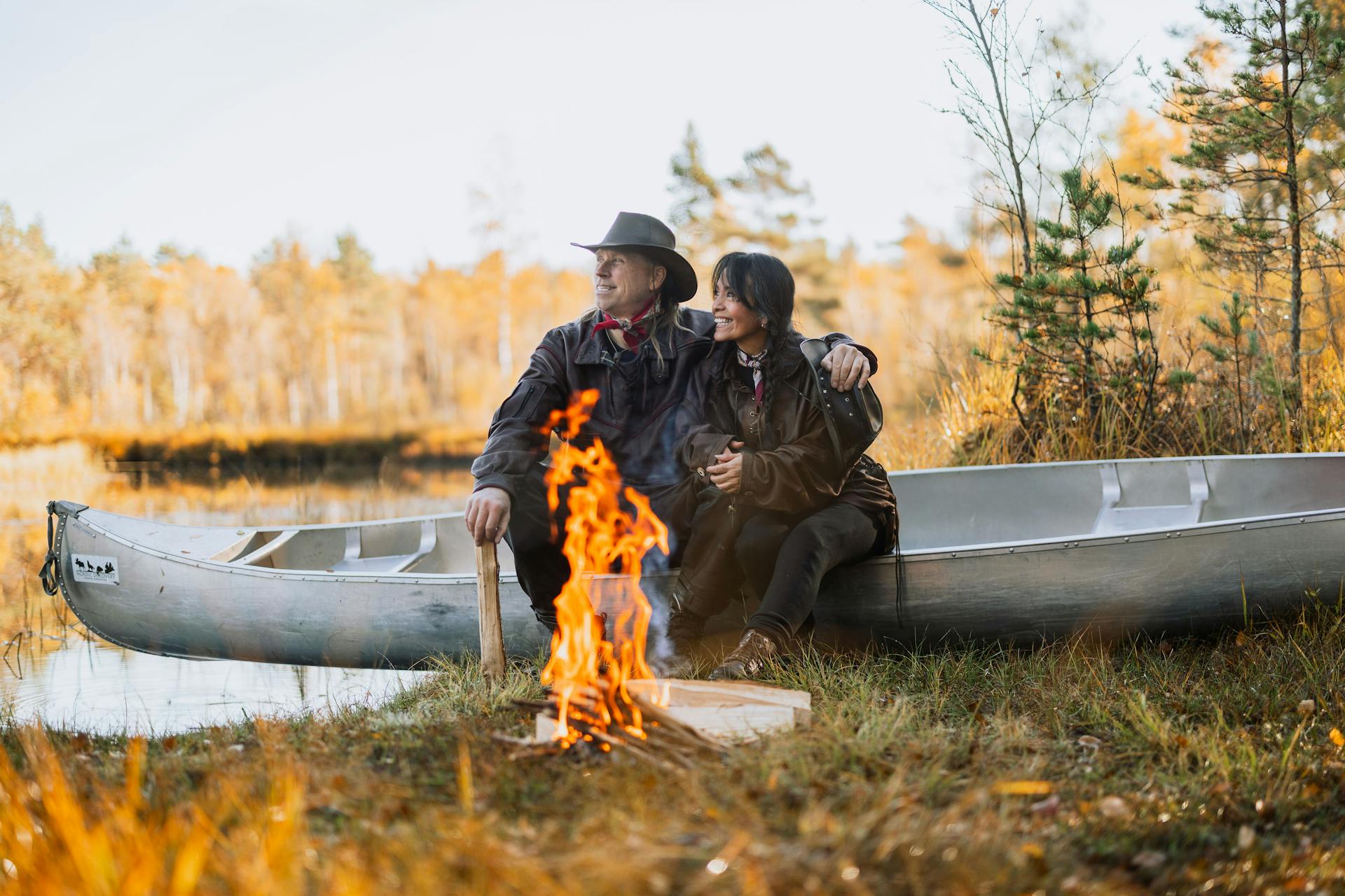 Una pareja disfrutando de una hoguera durante un viaje en canoa en la naturaleza sueca con Nordic Discovery.