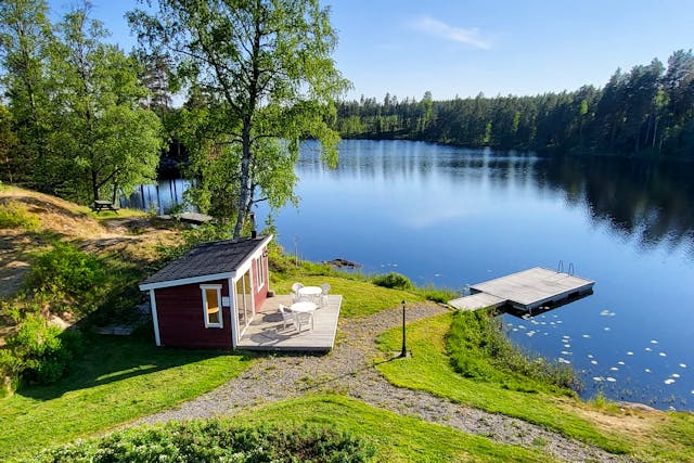 Bastun på River Lodge omgiven av vattnet i den djupa svenska skogen.