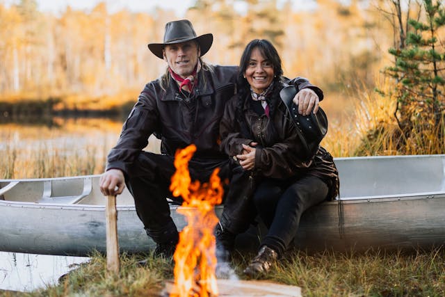 Les fondateurs de Nordic Discovery sont assis autour d'un feu de camp sur un canoë.